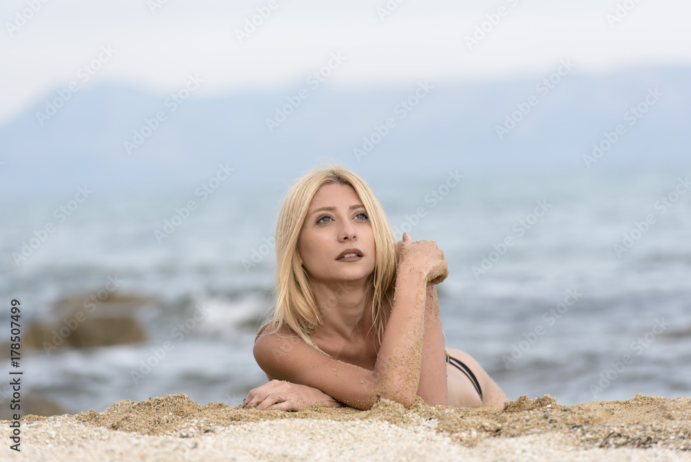 Slim gorgeous blonde woman lying topless on sand, photo in horizontal Slim gorgeous blonde woman lying topless on sand, photo in horizontal