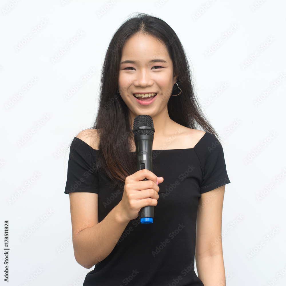 Happy asian girl singing with a microphone isolated on white background Happy asian girl singing with a microphone isolated on white background