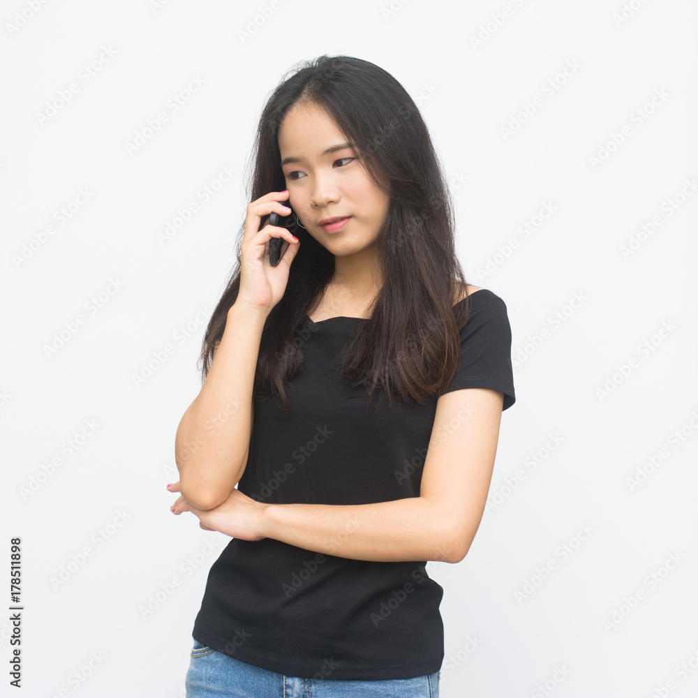 Happy asian young girl talking on a phone isolated on white background.. Happy asian young girl talking on a phone isolated on white background..