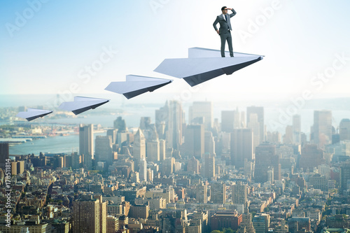 Businessman flying on paper plane in business concept