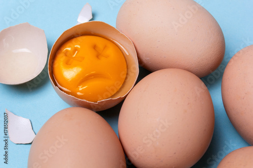 One chicken egg is broken and the yolk is sad or dead. Rotten egg photo