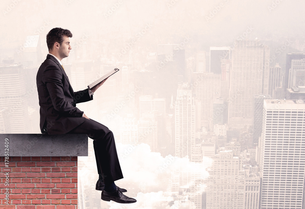 Office worker sitting on rooftop in city Office worker sitting on rooftop in city