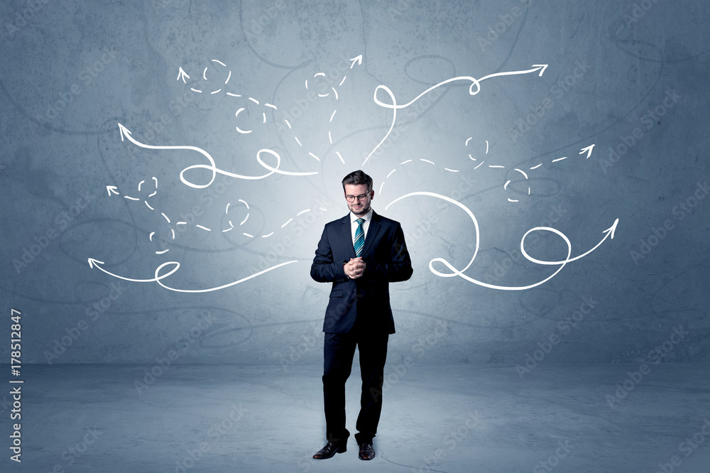 Businessman standing with winding arrows around Businessman standing with winding arrows around