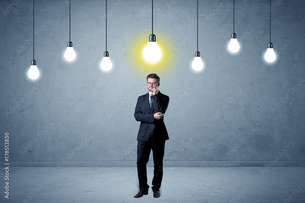 Businessman standing uninspired with bulbs above Businessman standing uninspired with bulbs above