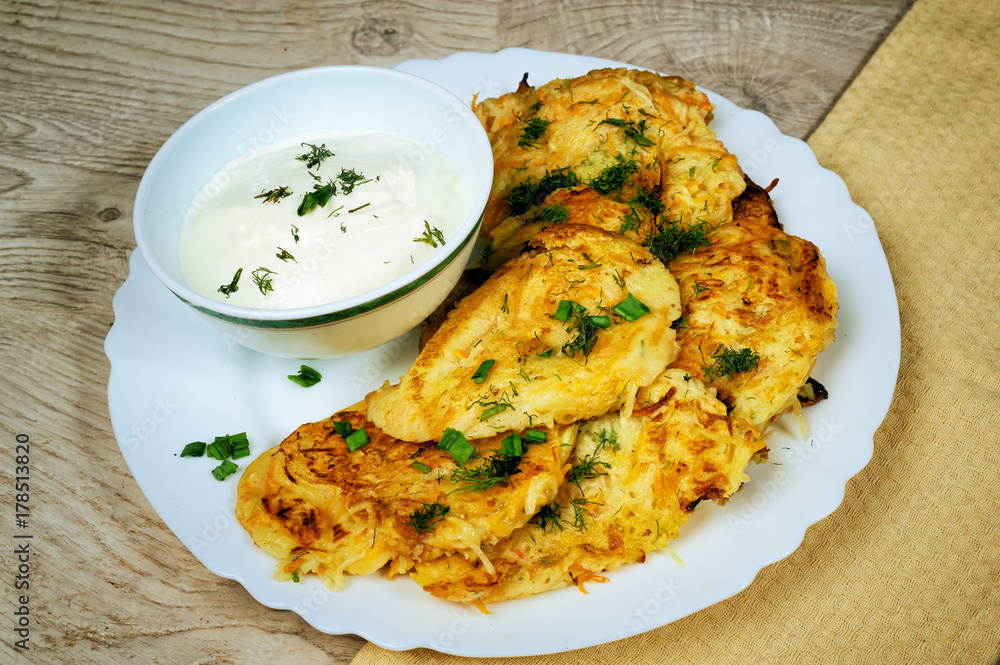 Fried potato pancakes with sour cream on old wooden background . Traditional Ukrainian cuisine Fried potato pancakes with sour cream on old wooden background . Traditional Ukrainian cuisine