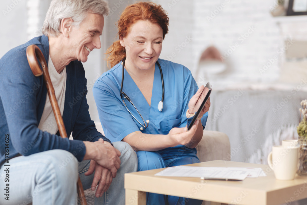 © zinkevych - Friendly senior patient and nurse looking tablet computer © zinkevych - Friendly senior patient and nurse looking tablet computer