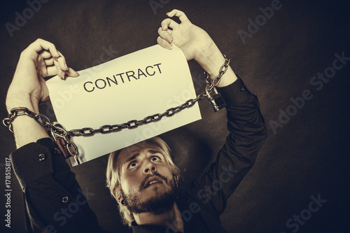 Man with chained hands holding contract photo