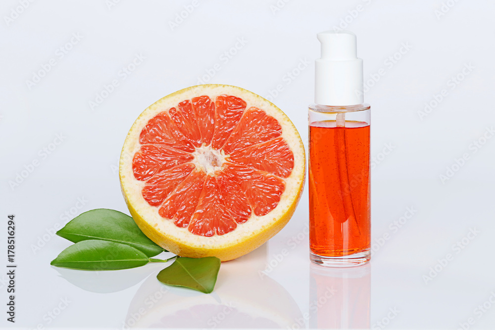 Serum for face with grapefruit extract. Orange citrus serum with essential oil of grapefruit and grapefruit in a section . Organic cosmetics with citrus extract Serum for face with grapefruit extract. Orange citrus serum with essential oil of grapefruit and grapefruit in a section . Organic cosmetics with citrus extract