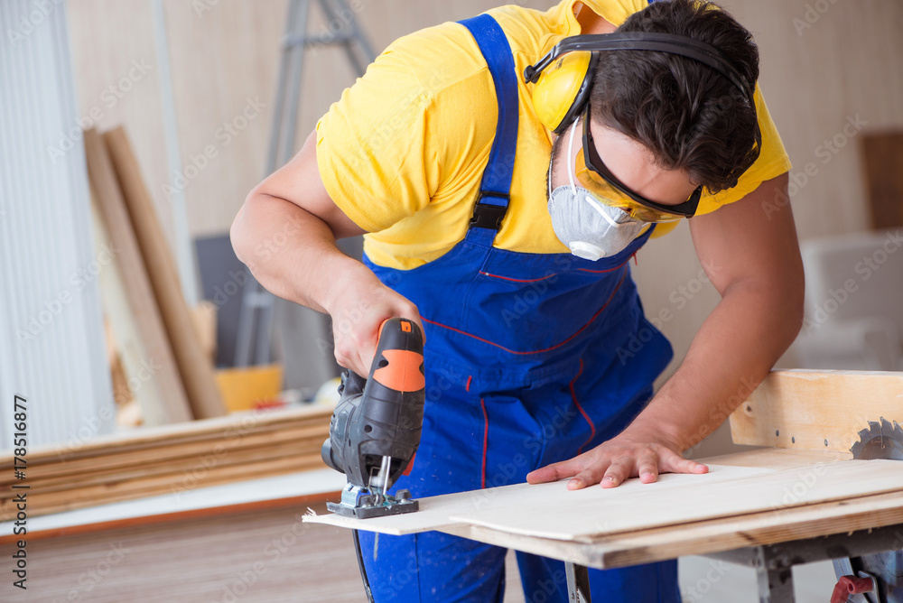 Young repairman carpenter working with a circular saw Young repairman carpenter working with a circular saw