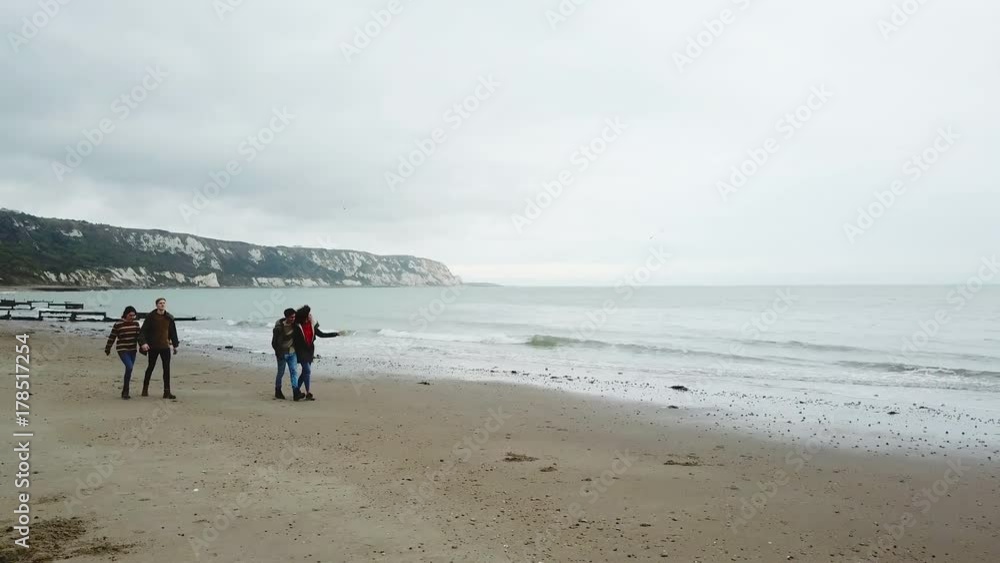 Aerial shot of friends walking along beach Aerial shot of friends walking along beach