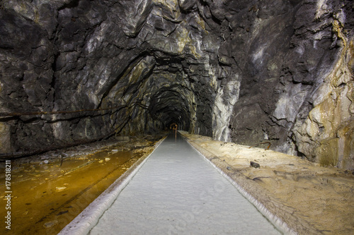 underground ore tunnel gallery with white limestone dirt and rails