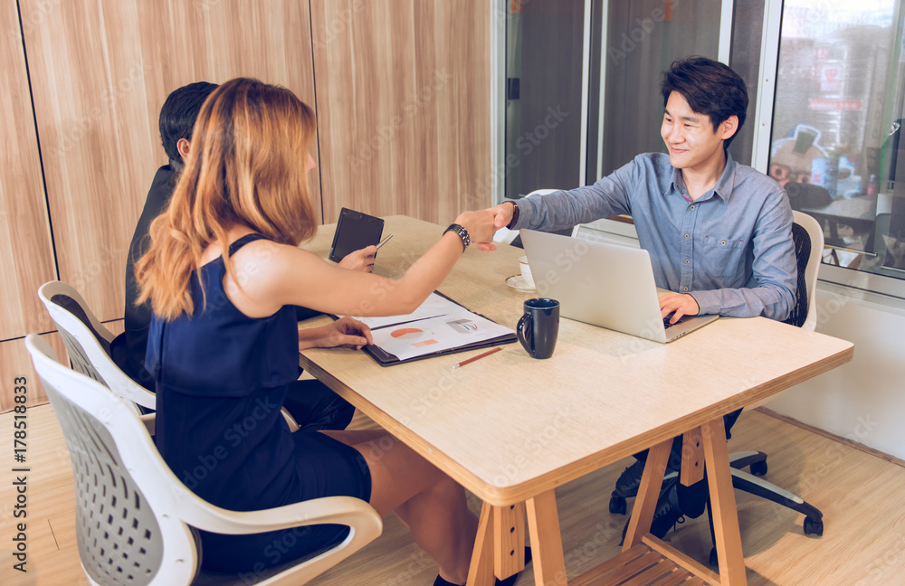 Happy asian Businessman and women shake hands in office, strike a bargain on deal concept. Happy asian Businessman and women shake hands in office, strike a bargain on deal concept.