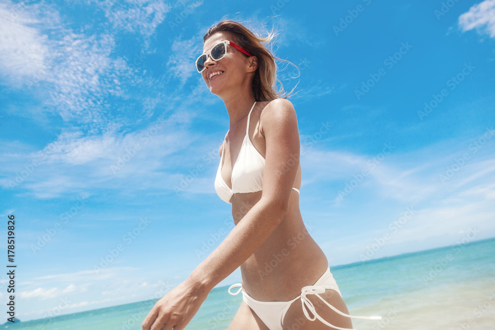 Sexy bikini body woman playful on paradise tropical beach having fun playing splashing water in freedom. Beautiful fit body girl on travel vacation