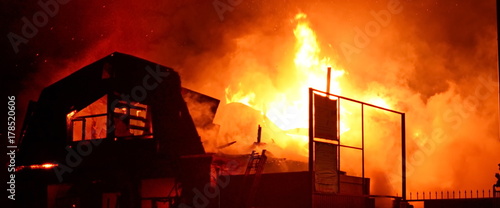 bright fire from the window of the roof of the burning house at night