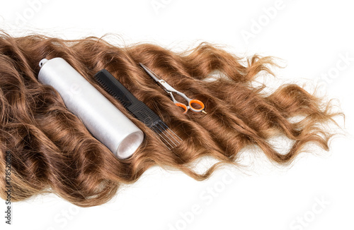 Curled hair strand, tool set and spray isolated on white