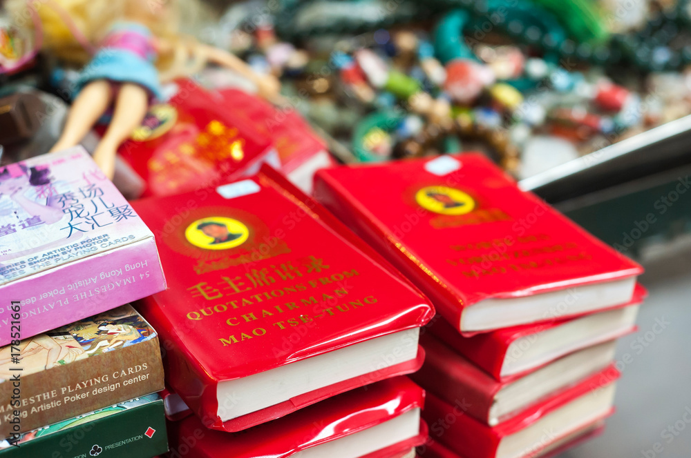 Naklejka premium Mała Czerwona Księga Prezesa Mao w sprzedaży na targu ulicznym Upper Lascar Row, Sheung Wan, Hongkong