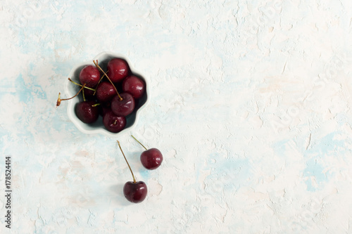 Top view flat lay cherry in bowl on blue and white background
