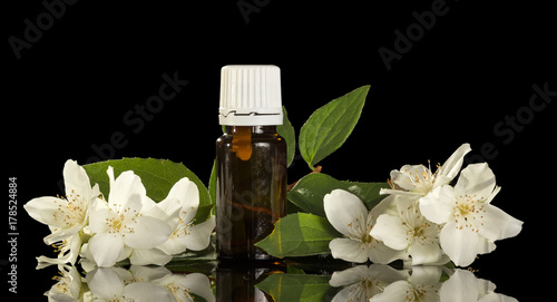 Liquid with floral scent  for smoking electronic cigarette and jasmine flowers isolated on black
