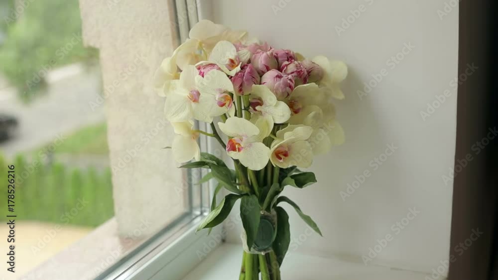 Wedding bouquet of orchids on the window closeup. Camera movement from the bottom up. Wedding bouquet of orchids on the window closeup. Camera movement from the bottom up.