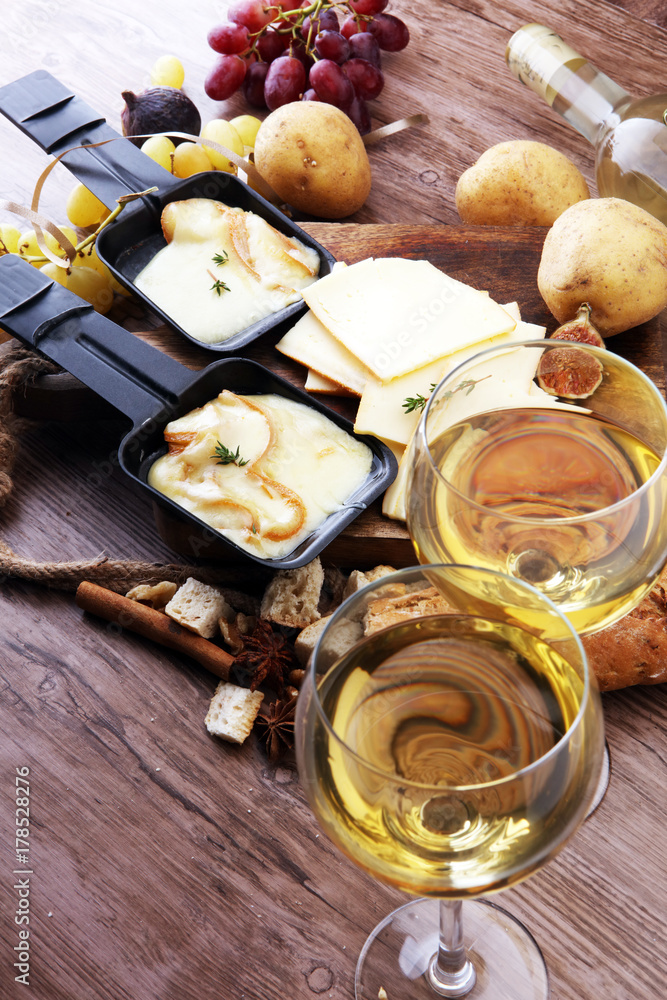 Delicious traditional Swiss melted raclette cheese on diced boiled or baked potato served in individual skillets Delicious traditional Swiss melted raclette cheese on diced boiled or baked potato served in individual skillets
