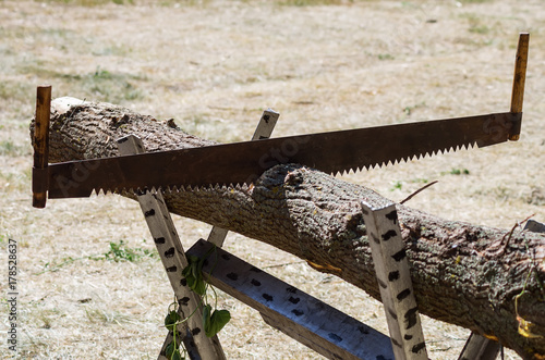 Photos Two-handed saw in a beam on a trestle / Photo taken in Russia, in the courtyard