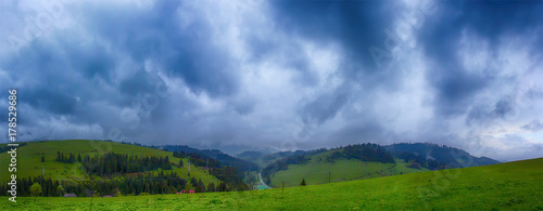 Mountain with green hills and pine trees on the slopes of a cloudy overcast