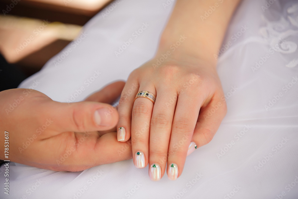 Wedding concept. Bride and groom holding hands. Wedding or engagement ring. Newlyweds in love