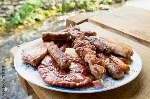 Serbian specialities known as rostilj include grilled pork neck, beef steak, pleskavica, cevapi and are served with homemade buns and tortillas photo