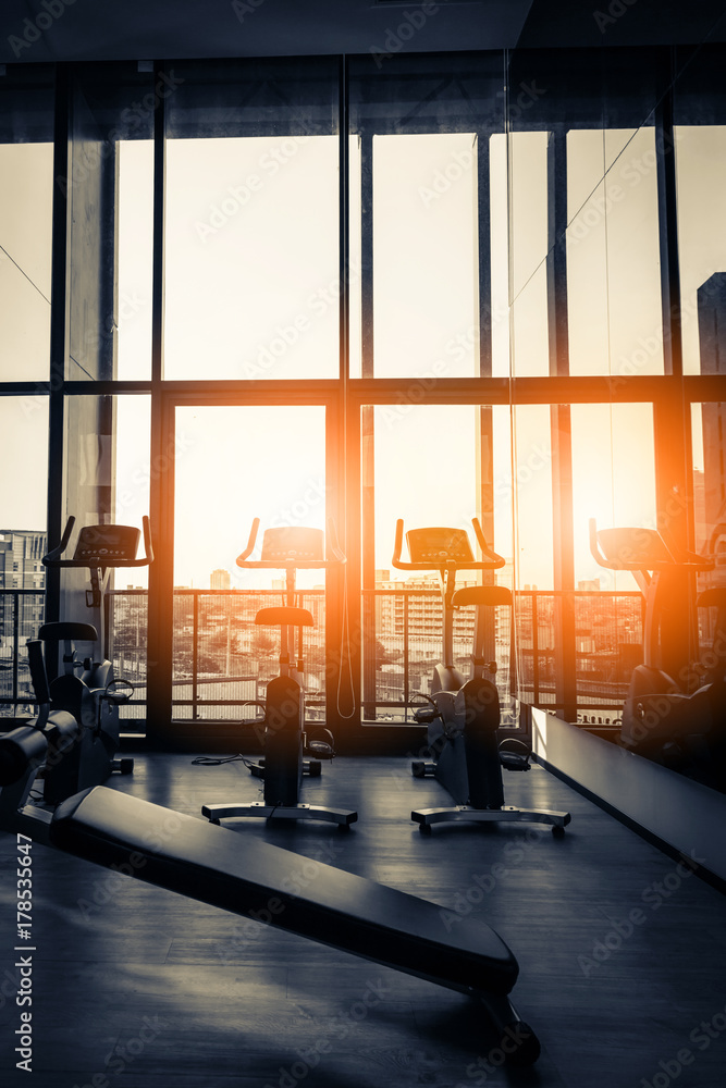 Modern gym interior with equipment. Row of training exercise bikes