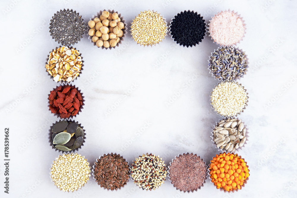 Various superfoods, seeds, cereals, grains on a white marble background. Top view, copy space for text