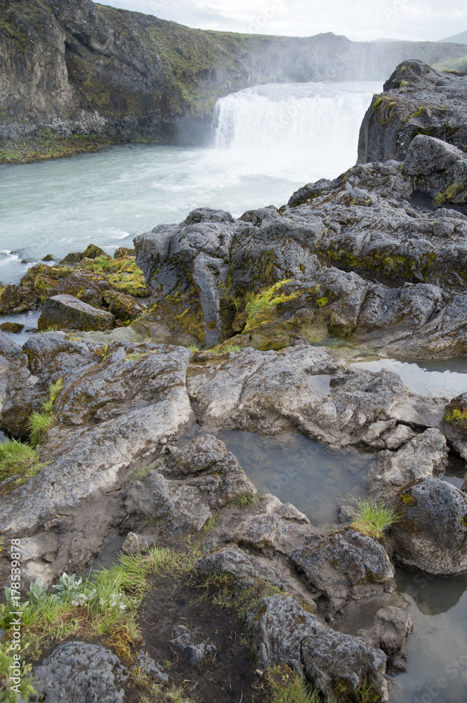 Wonderful view of Gadafoss Falls in a typical Icelandic landscape, a wild nature of rocks and shrubs, rivers and lakes. Wonderful view of Gadafoss Falls in a typical Icelandic landscape, a wild nature of rocks and shrubs, rivers and lakes.