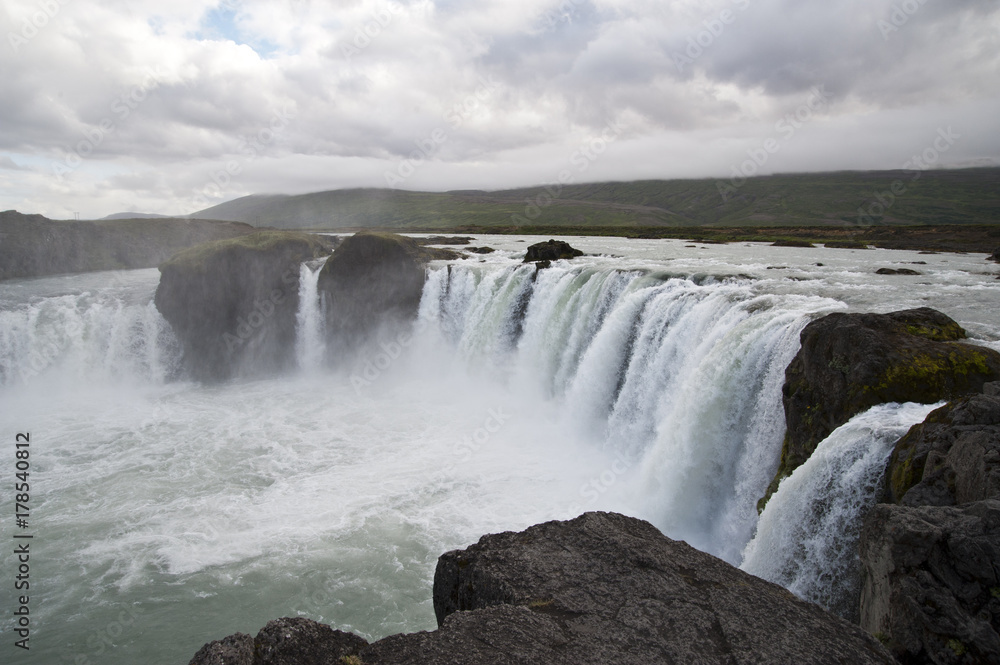 Wonderful view of Gadafoss Falls in a typical Icelandic landscape, a wild nature of rocks and shrubs, rivers and lakes. Wonderful view of Gadafoss Falls in a typical Icelandic landscape, a wild nature of rocks and shrubs, rivers and lakes.