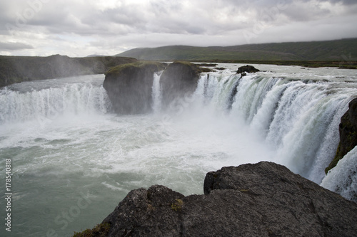 Wonderful view of Gadafoss Falls in a typical Icelandic landscape, a wild nature of rocks and shrubs, rivers and lakes. © RiCi