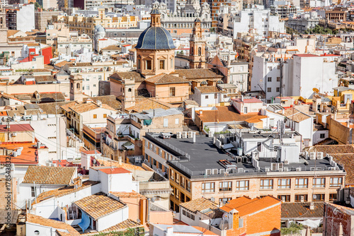 Top cityscape view on the old residential buildings with church in Valencia city during the sunny day in Spain