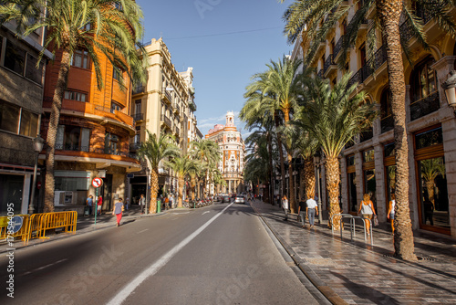 Street view with beautiful luxurious building and palm trees in Valencia city during the sunny day in Spain