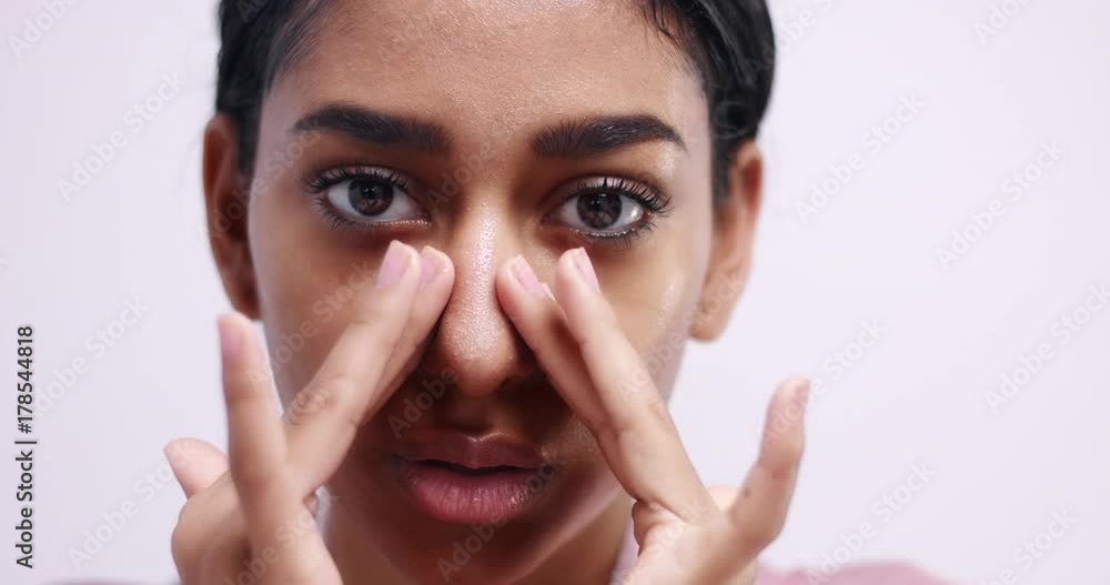 Beautiful Eastern girl with perfect olive skin gently massaging her face after removing a sheet mask on white background Beautiful Eastern girl with perfect olive skin gently massaging her face after removing a sheet mask on white background