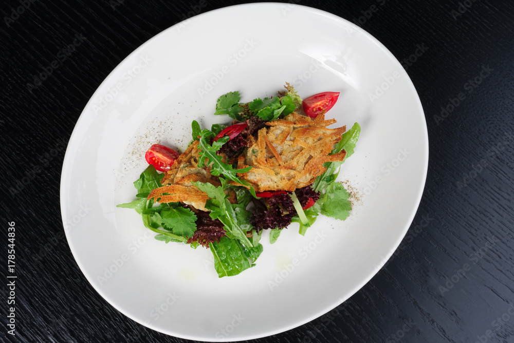 salad with chicken fillets on a white plate black background salad with chicken fillets on a white plate black background