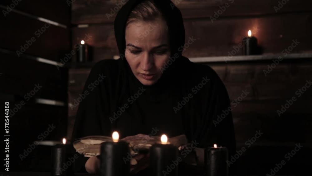 Nun is reading old book highlights the flame of a candle. Christianity concept Nun is reading old book highlights the flame of a candle. Christianity concept