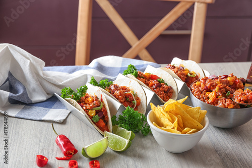Bilde på lerret Delicious tacos with chili con carne on table