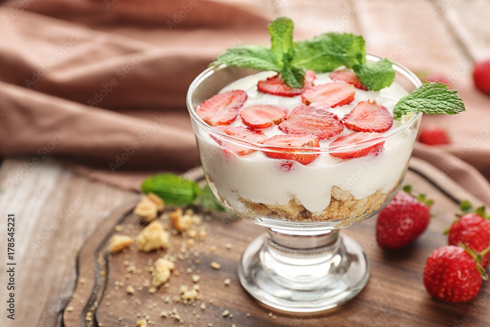 Glass of delicious strawberry dessert on wooden board Glass of delicious strawberry dessert on wooden board