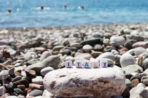 The word Italy on the pebbles on the sea shore