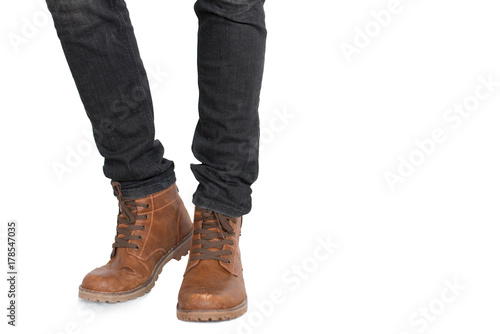 Lower half of Man leg and foot wearing jeans and shoes on isolated white background. Fashion and people concept. Parts of body theme.