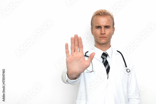 Doctor with stethoscope show off "stop" or "not allowed" sign by his hand on the white background. Medical and Healthcare concept. Hospital theme © Shutter2U