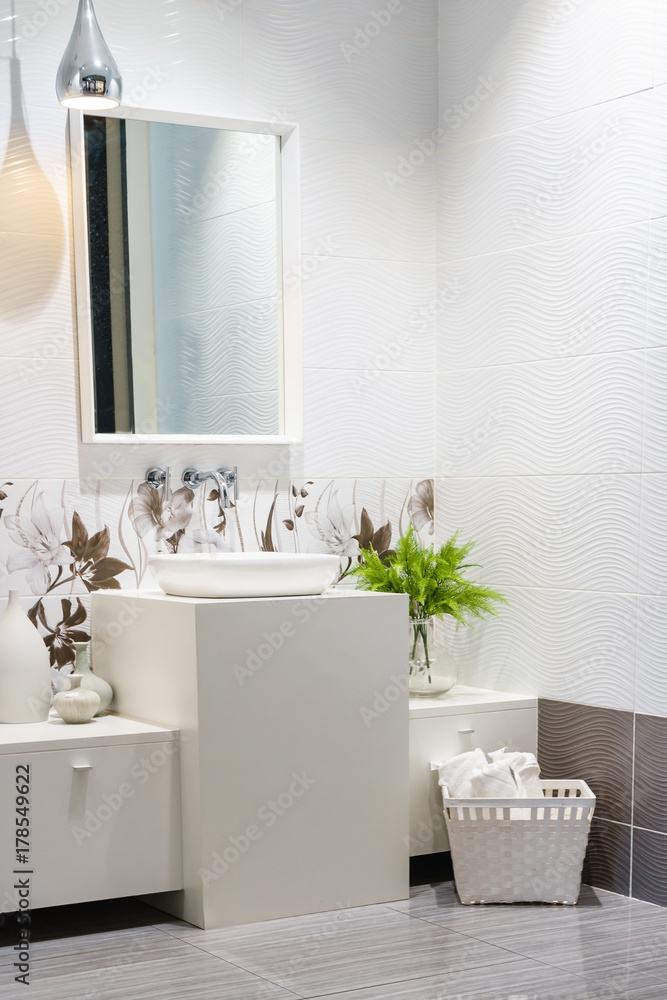 Fototapeta premium Modern spacious bathroom with bright tiles with toilet and sink. Side view