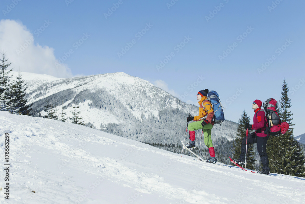 Winter Trekking in the mountains. Two men make an ascent to the top.