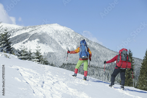 Winter Trekking in the mountains. Two men make an ascent to the top.