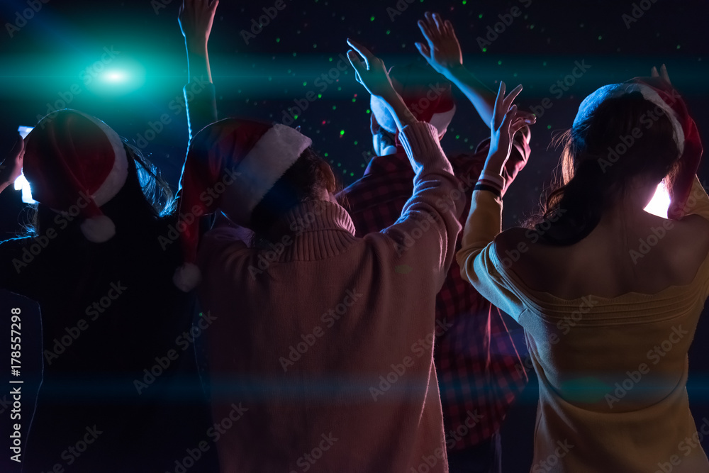 Group Asian young friends dancing Together party with Disco lights celebrating Christmas at dark home