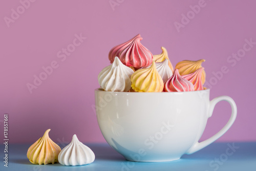 Fotografie Dessert with meringue, a lot of colorful meringues in the tea Cup