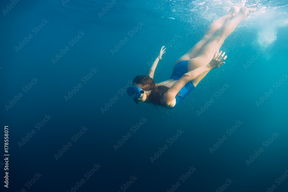 Young woman swimming in ocean, snorkeling underwater view