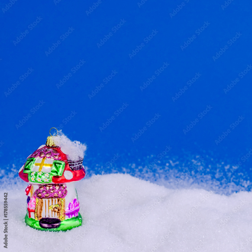 colorful xmas house in snow on blue background. Christmas and New Year concept. Christmas greeting card.